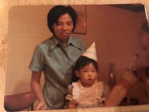 My mother and me as a toddler wearing a birthday hat