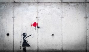 Photo of stencil wall art, a girl letting a red heart balloon go
