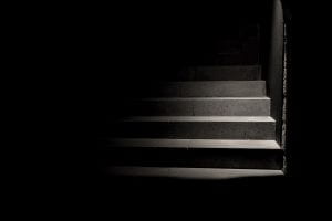 Photo of a semi-lit staircase against a dark background