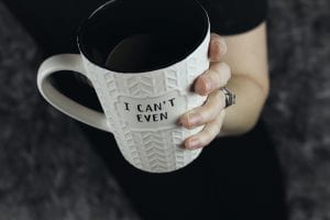 Woman's hand holding a mug that reads "I Can't Even"