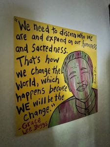 Photo of painting of Grace Lee Boggs with quote, "We need to discern who we are and expand on our humanness and sacredness. That's how we change the world, which happens because WE will be the change" -- Grace Lee Boggs