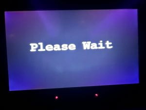 Picture of a violet screen with the words "Please Wait" in white letters